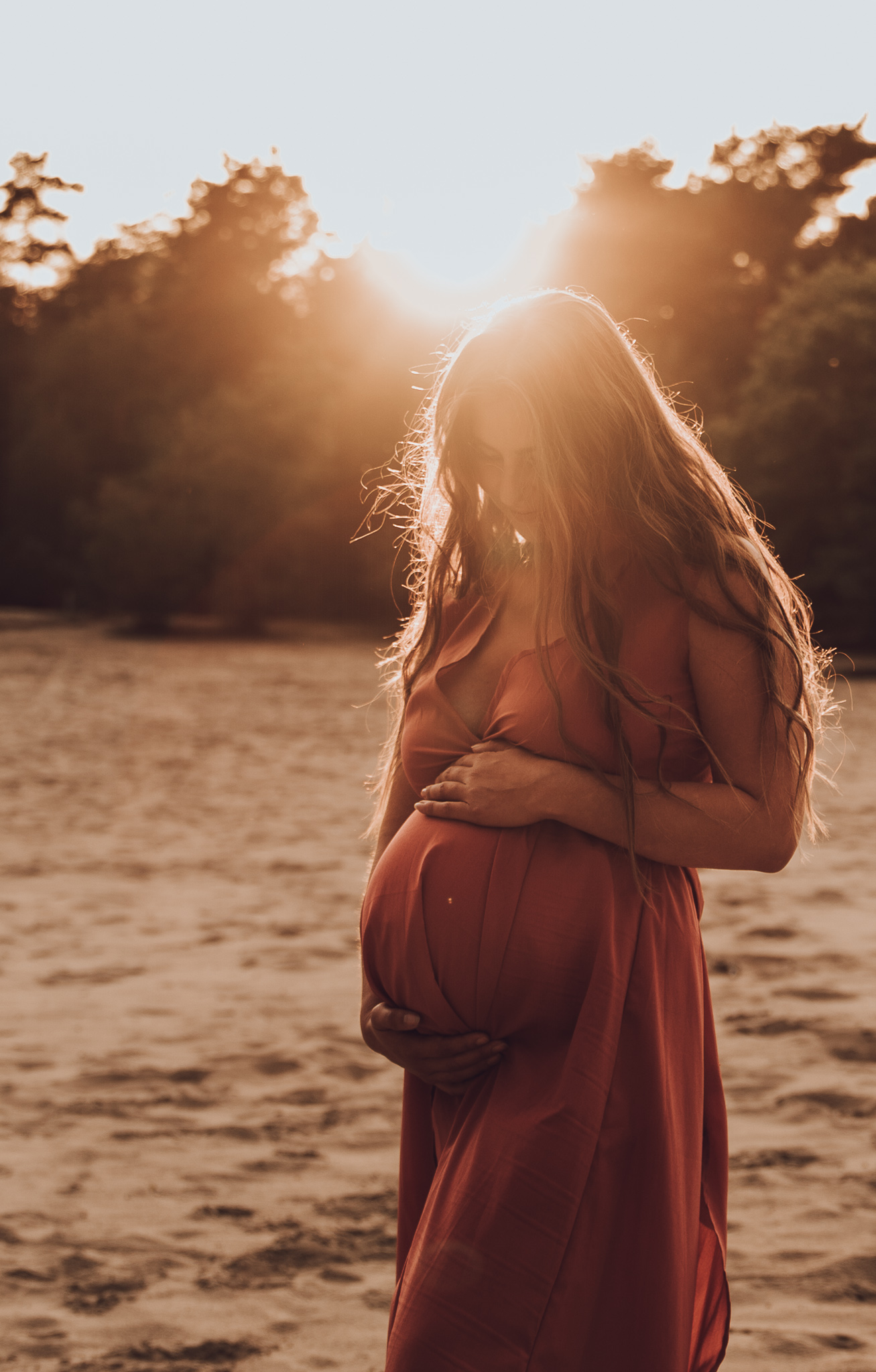 Zwangerschapsfotoshoot door flow photography, zwangere kijkend naar buik