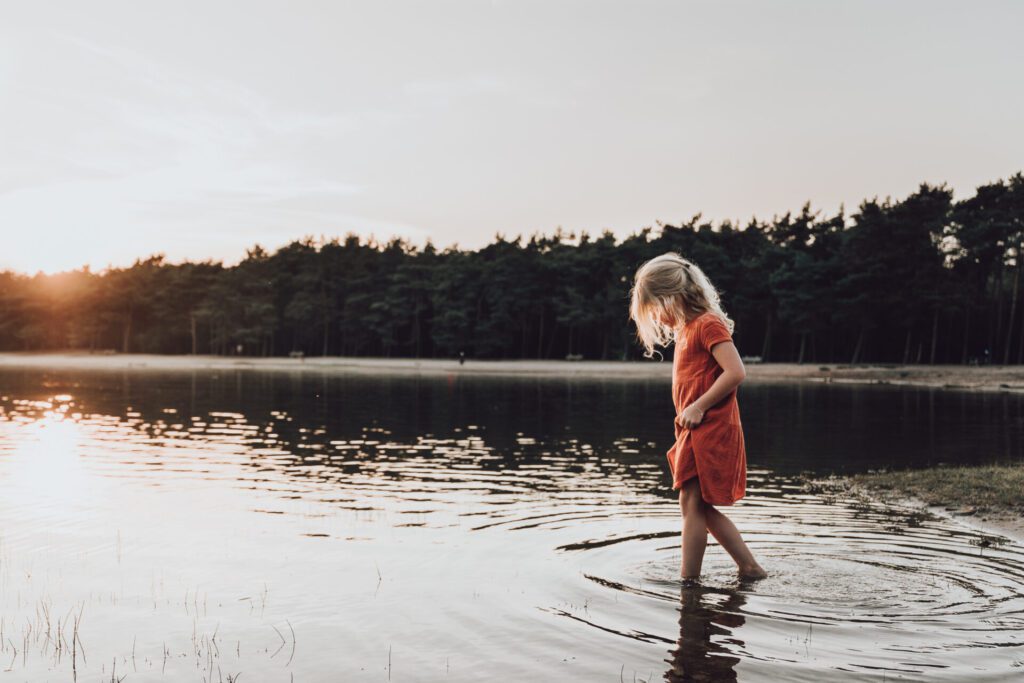 Foto van een meisje in het water tijdens een gezinsfotoshoot door flow photography